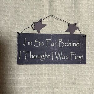 “I’m so far behind I thought I was first” wood sign with wire and metal stars
